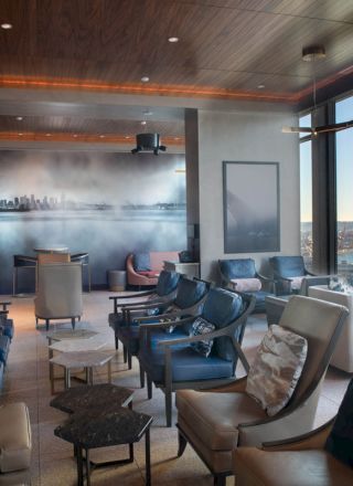 This image shows a modern lounge with seating, large windows providing a scenic view, and contemporary décor.